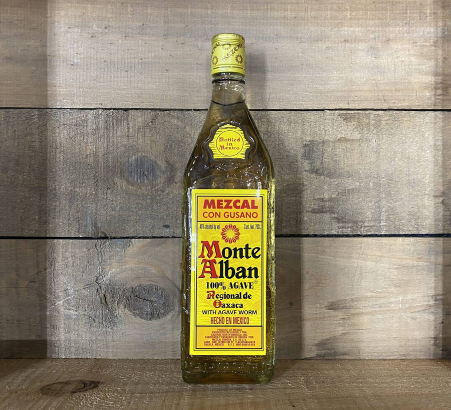 Monte Alban Mezcal Tequila Beside Wooden Wall Wallpaper