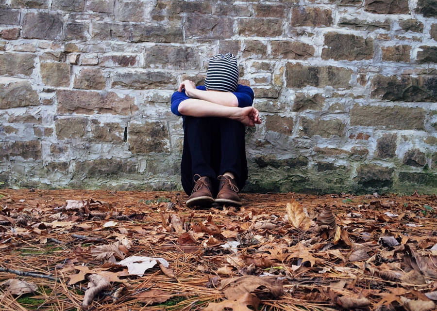 Mood Off Boy Leaning On A Wall Wallpaper