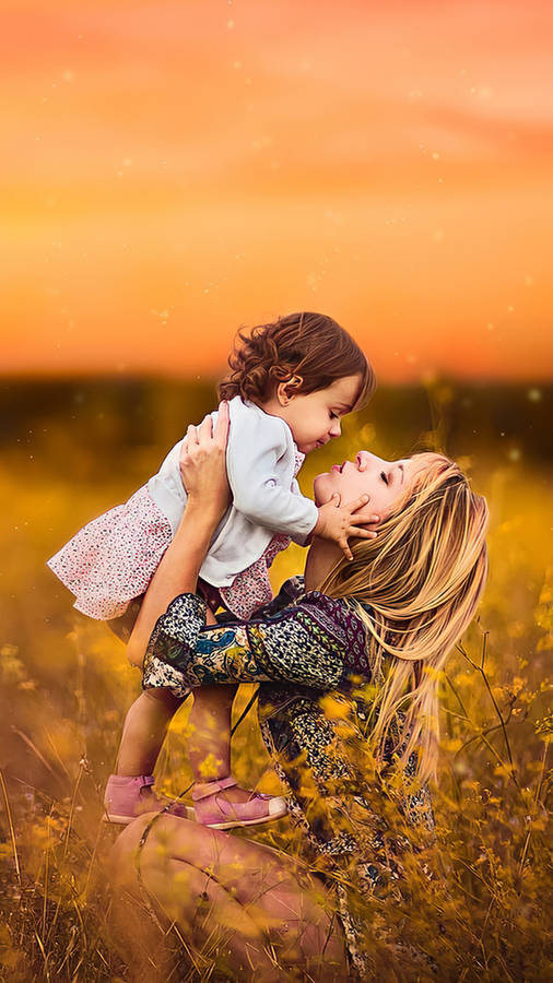 Mother And Daughter In Flower Garden Wallpaper