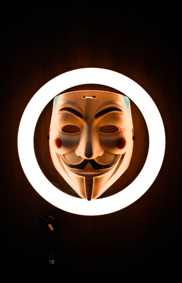 Mysterious Hacker In Mask Illuminated By Ring Light Wallpaper