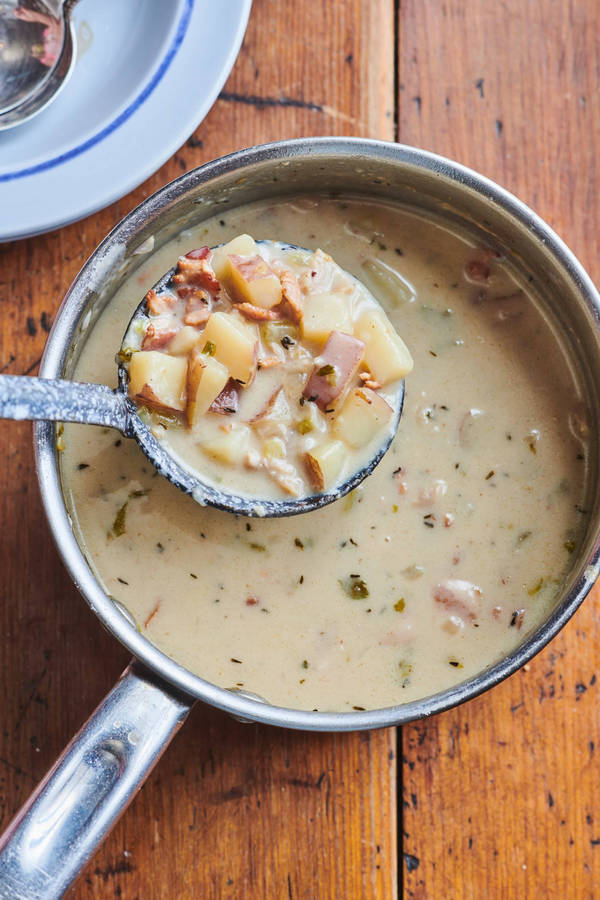 New England Clam Chowder Soup In Silverware Scoop Wallpaper