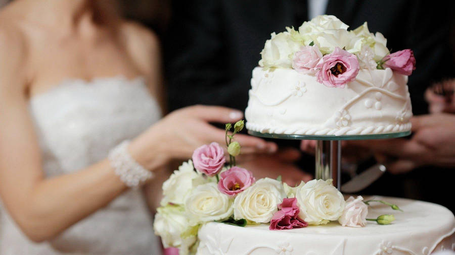 Newlyweds Slicing Floral Wedding Cake Wallpaper