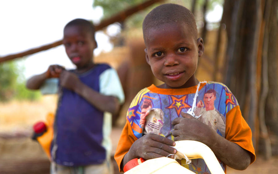 Nigerian Boys Collecting Water In Plastic Containers Wallpaper