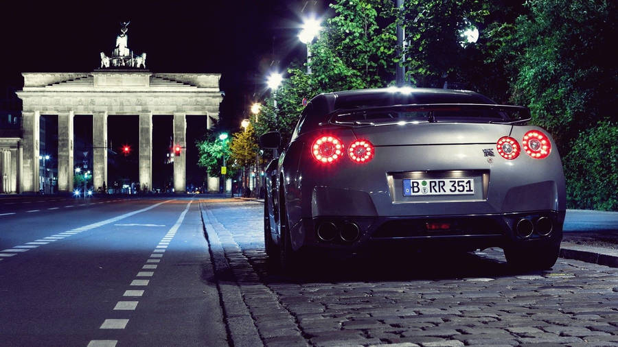 Nissan Gtr Car Parked Near The Historical Gate Wallpaper