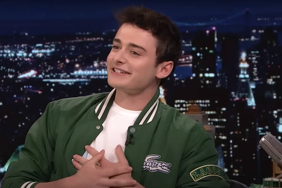 Noah Schnapp Stylishly Dressed In Green Lacoste Bomber Jacket Wallpaper