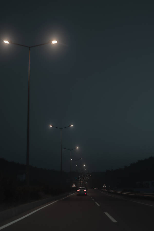 Old Street Lights Beside The Road On A Dim Evening Wallpaper