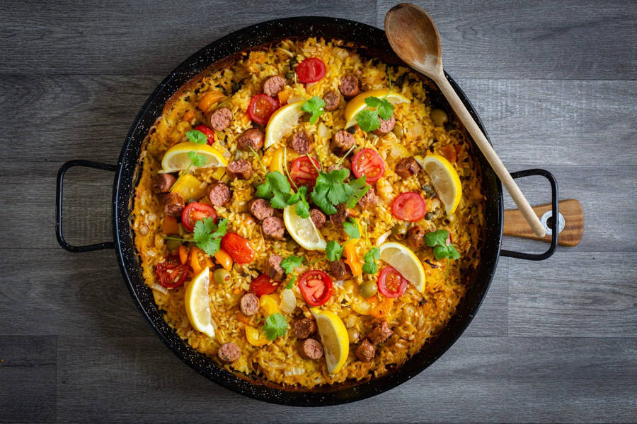 Paella Dish With Lemons And Sausages Wallpaper