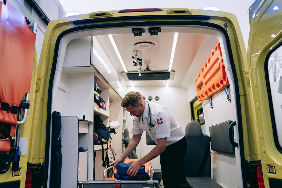 Paramedic Man Fixing Equipments Wallpaper