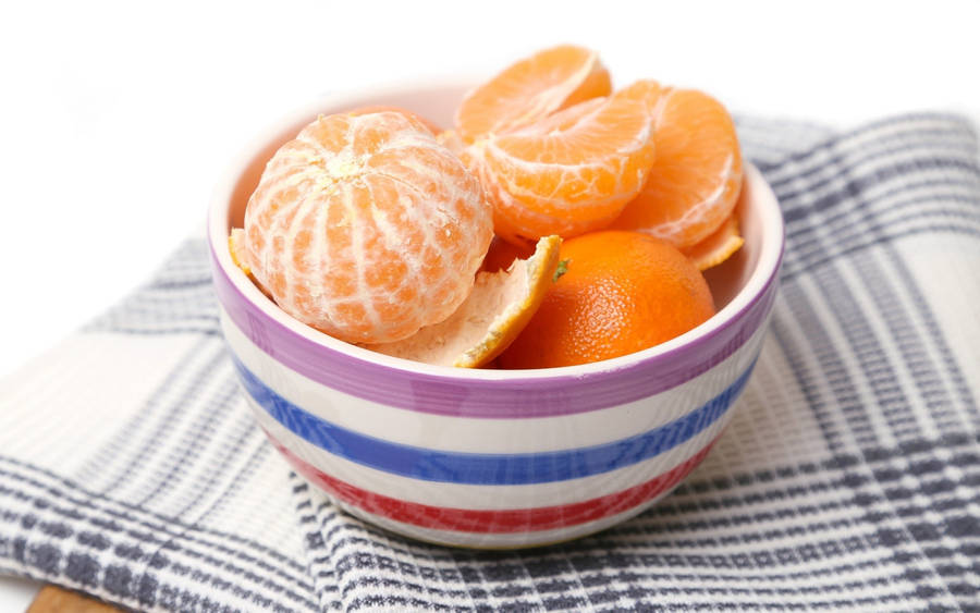 Peeled And Unpeeled Clementine Fruits In Bowl Wallpaper