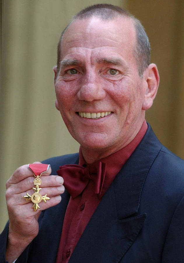 Pete Postlethwaite Receiving The Obe Medal Wallpaper