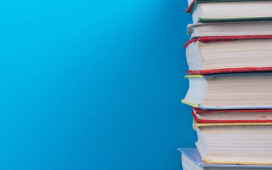 Pile Of Books On Blue Background Wallpaper