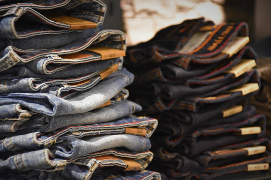 Pile Of Denim Jeans In Different Colors Wallpaper