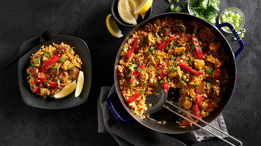 Plate And Pot Of Spicy Paella Wallpaper