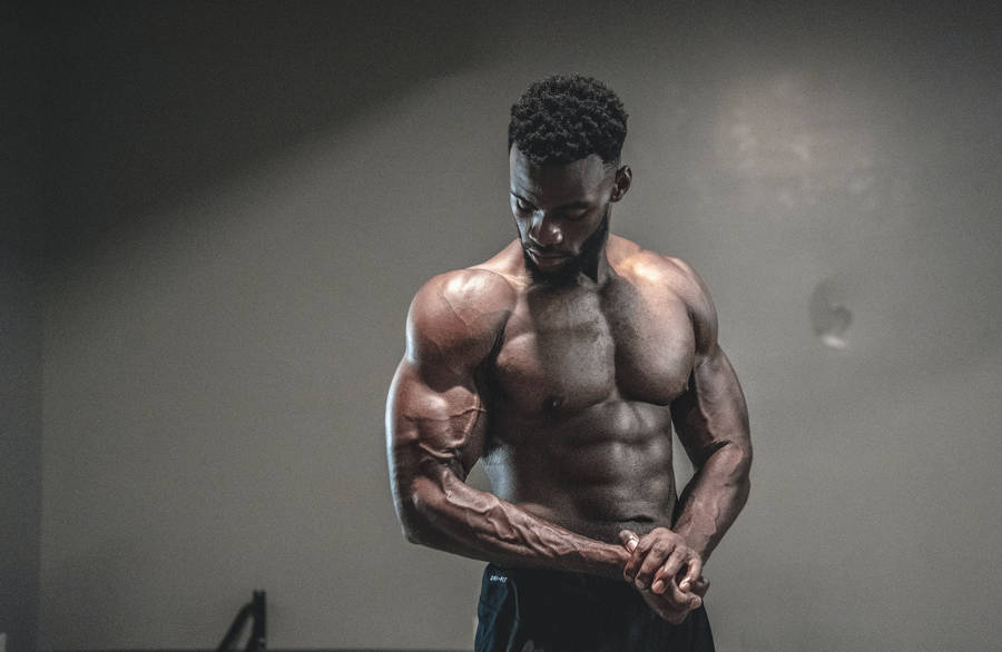 Powerful Black Man Showcasing His Muscular Physique Wallpaper