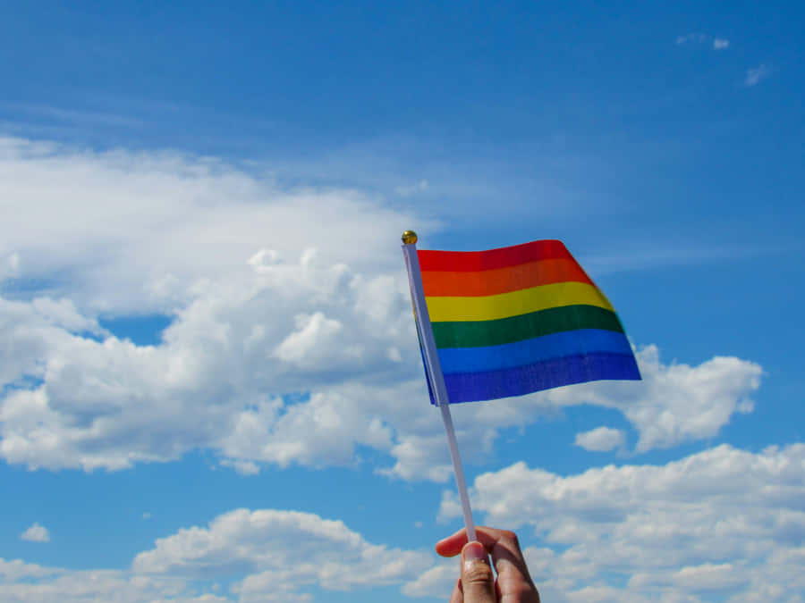 Pride_ Flag_ Waving_ Against_ Blue_ Sky Wallpaper