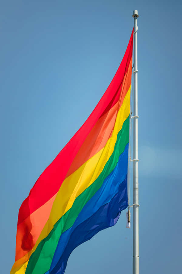 Pride_ Flag_ Waving_ Against_ Blue_ Sky Wallpaper