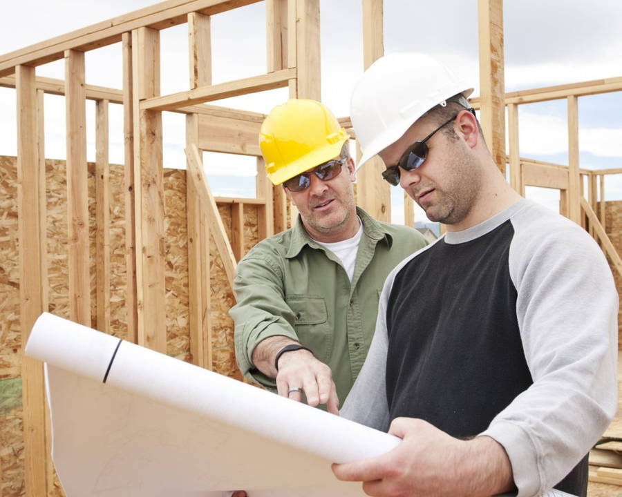 Professional Construction Workers Discussing Plans Wallpaper