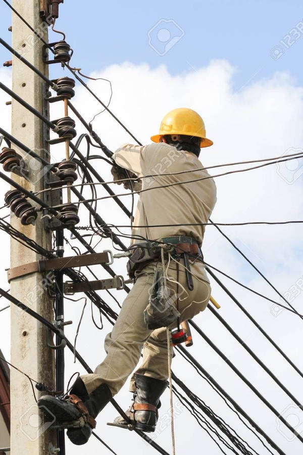 Professional Electrician Fixing An Electrical Post Wallpaper