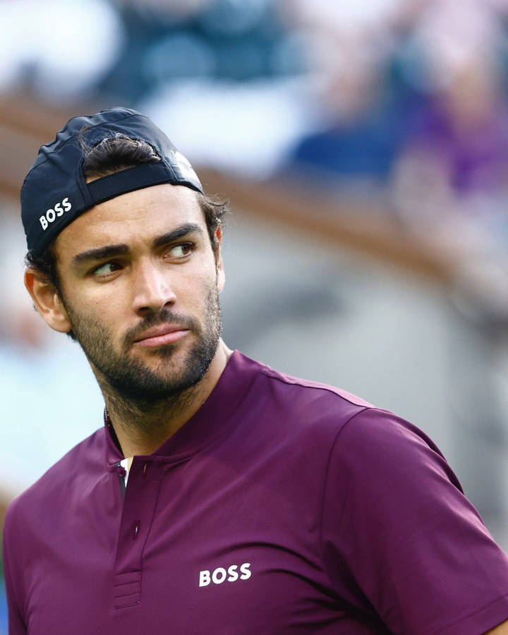 Professional Tennis Player Matteo Berrettini Wearing A Black Cap Wallpaper