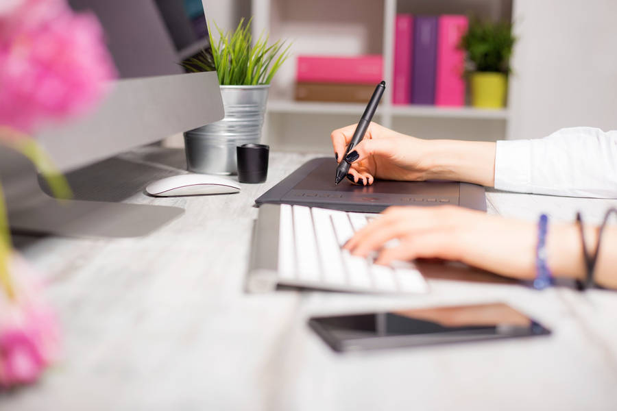 Professional Woman Creating Digital Content On Her Computer. Wallpaper