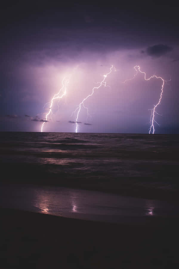 Purple Lightning Above Waves Wallpaper