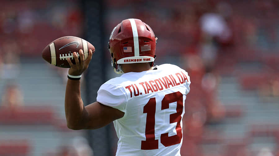 Quarterback Tua Tagovailoa Showing Off His University Of Alabama Helmet Wallpaper
