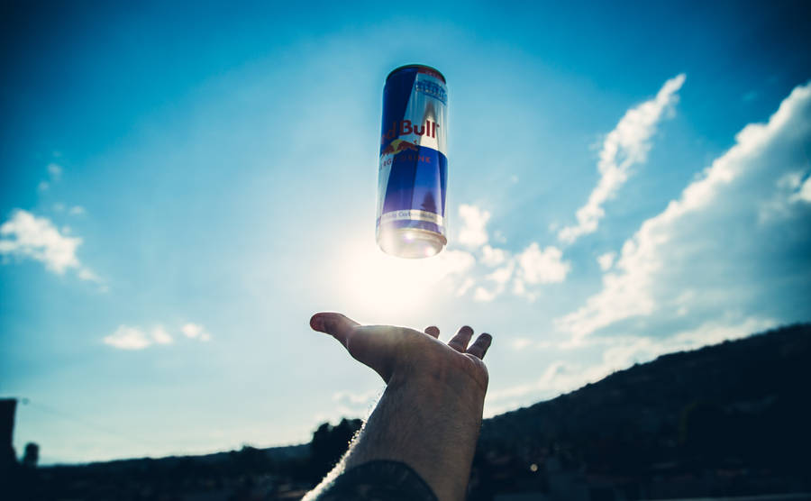 Red Bull Floating Above Hand Wallpaper