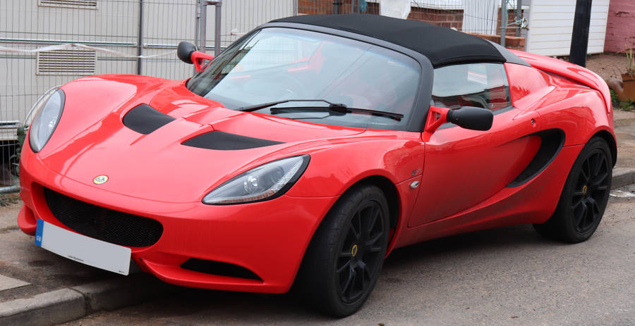 Red Lotus Elise Car Parked On Curb Wallpaper