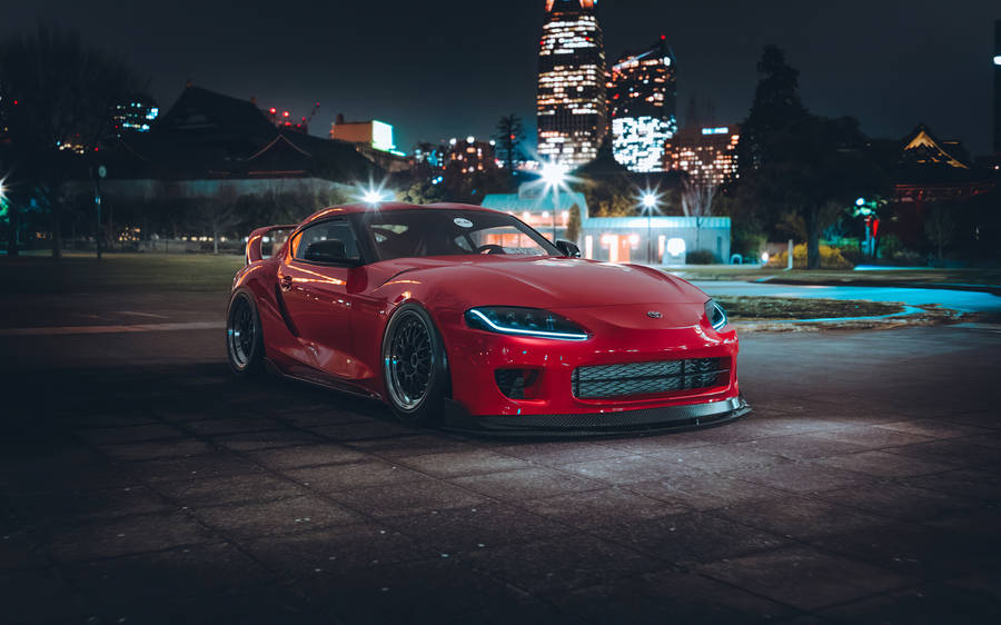 Red Toyota Supra Parked Near Cityscape Wallpaper