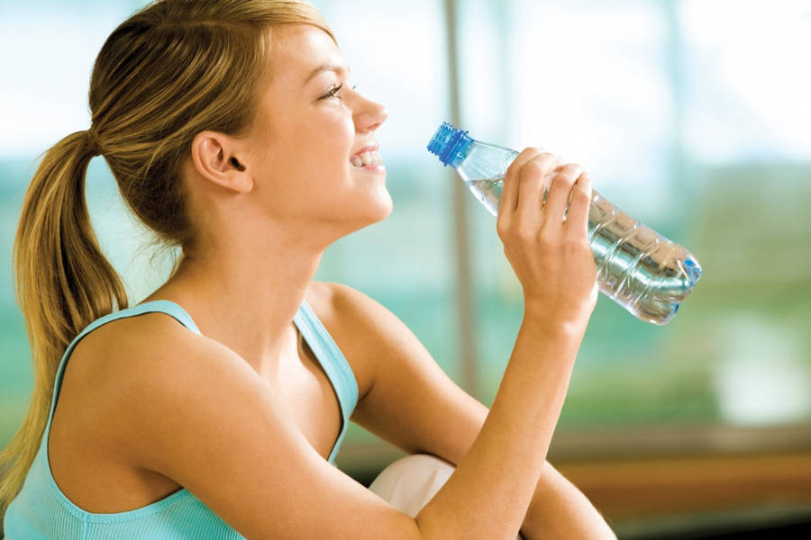 Refreshing Hydration - Woman Enjoying A Glass Of Clean Water Wallpaper