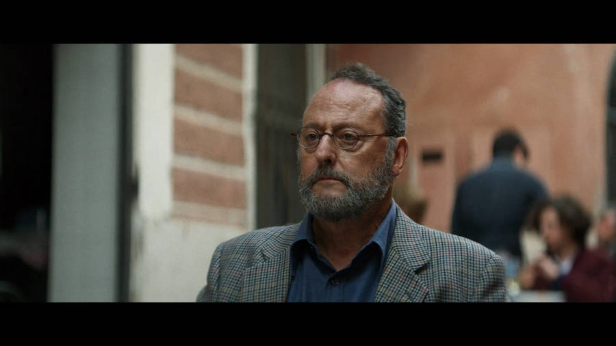 Renowned French Actor Jean Reno In A Candid Still From One Of His European Movies Wallpaper