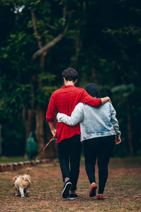 Romantic Couple Walking A Dog Wallpaper