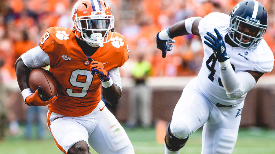 Running Back Travis Etienne With Ball Wallpaper