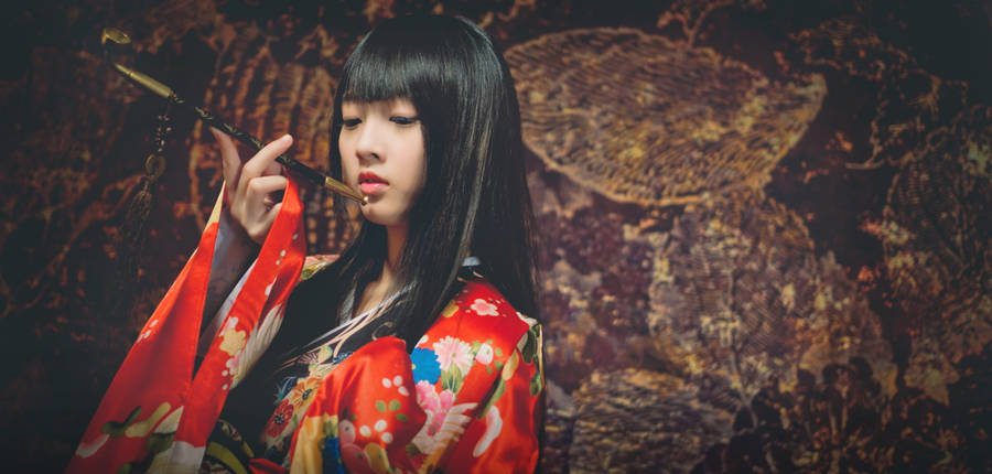 Serene Japanese Girl Enjoying A Pipe Wallpaper