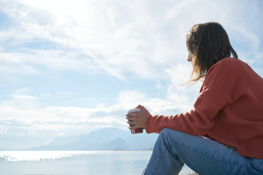 Serene Woman Enjoying Coffee In Solitude Wallpaper