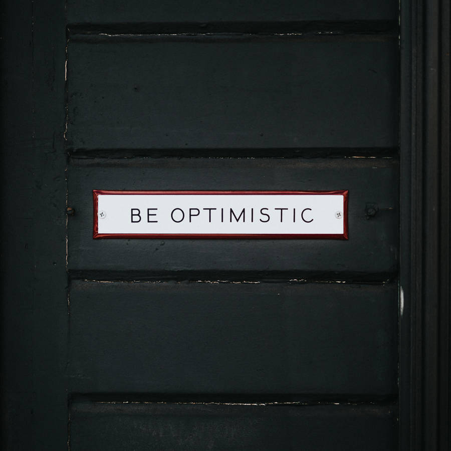 Shining Door Sign Displaying The Word Optimistic Wallpaper