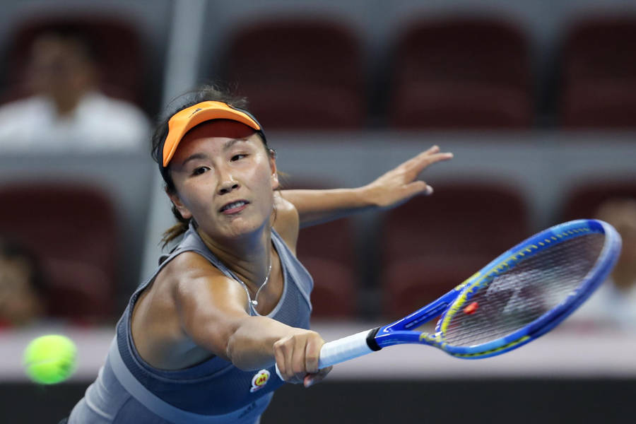 Shuai Peng Powerfully Reaching For A Tennis Ball In A Match Wallpaper