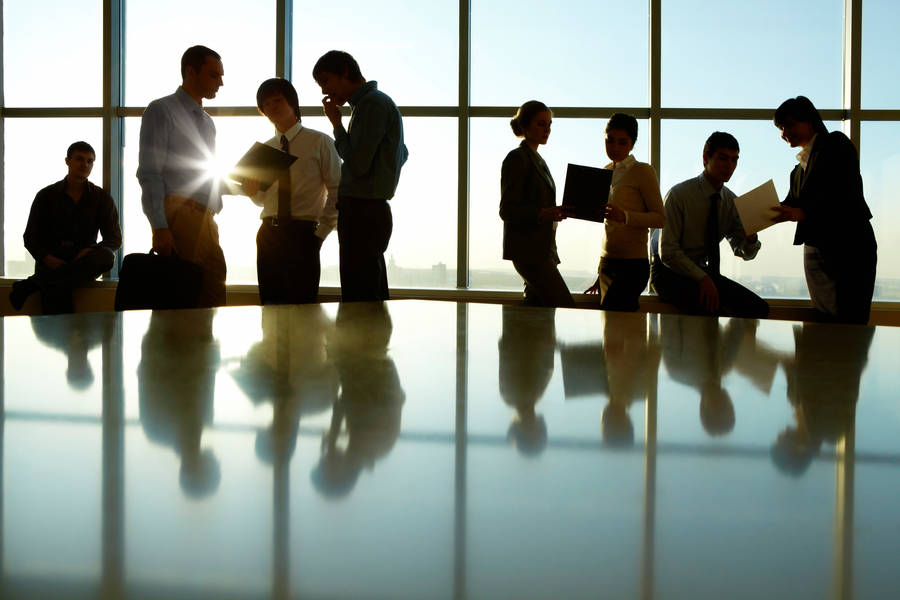 Silhouette Of Business Professionals Against Urban Skyline Wallpaper