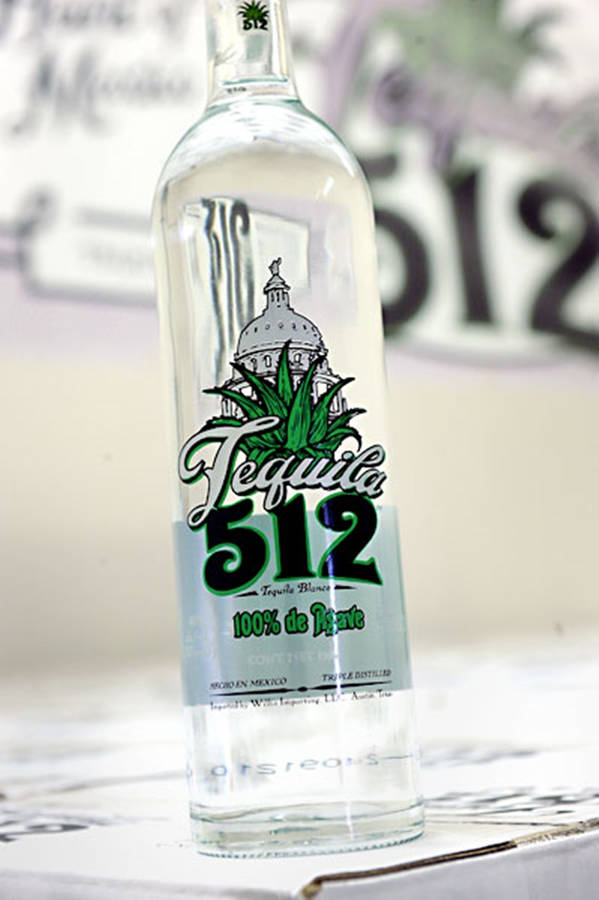 Sleek Bottle Of Tequila 512 On A Rustic Background. Wallpaper