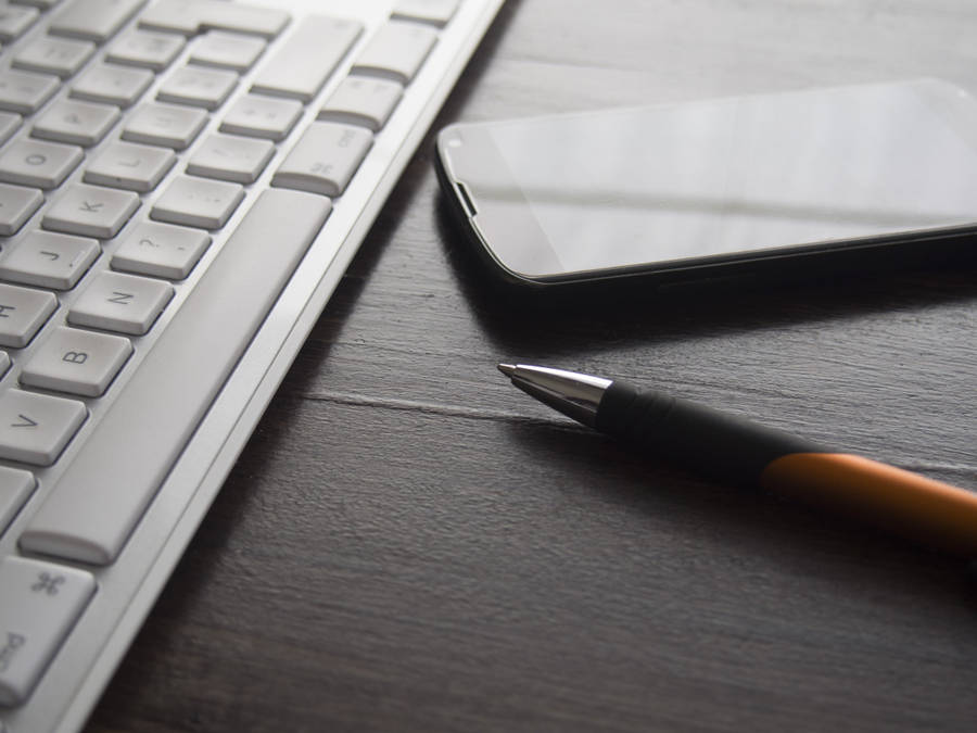 Sleek Computer Keyboard On A Desk Wallpaper