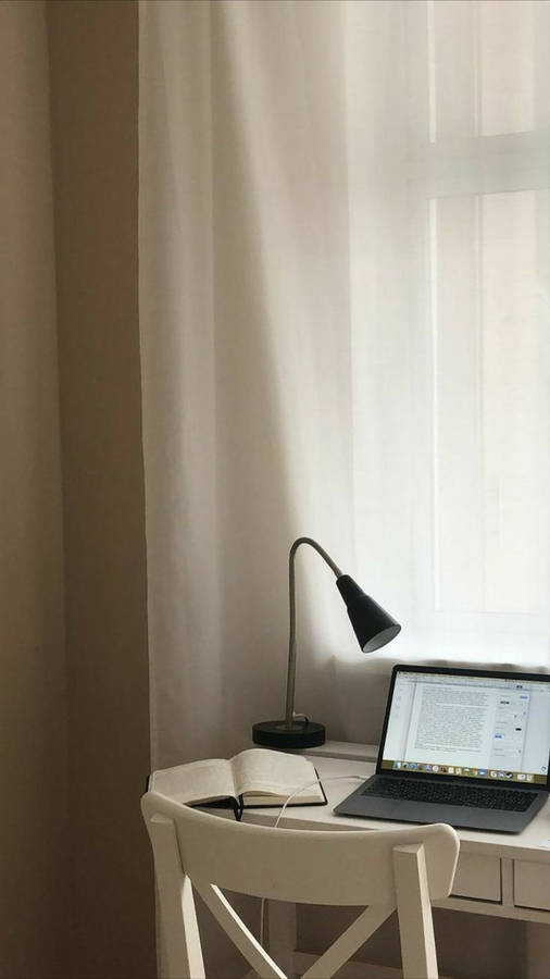 Sleek Iphone Desk Setup With Chic White Chair Wallpaper