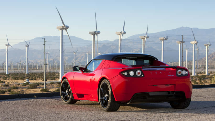 Sleek, Powerful Tesla Roadster Against Night Sky Wallpaper