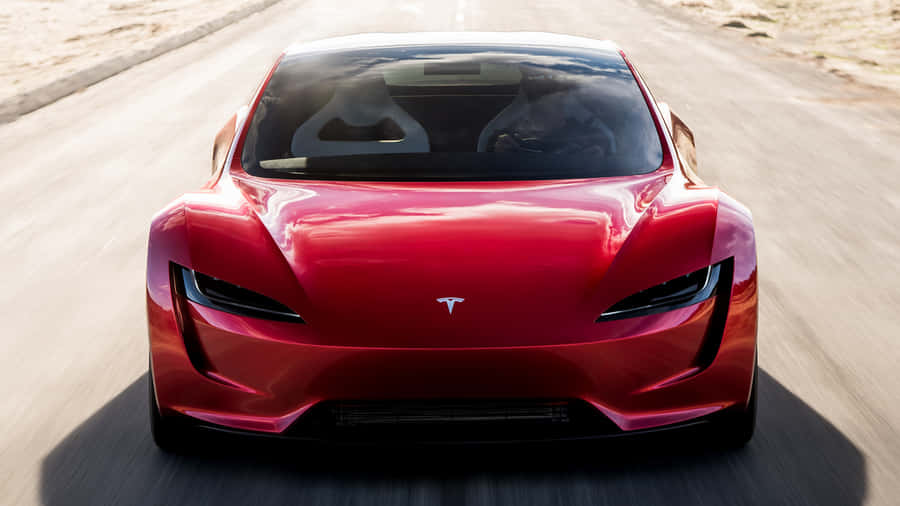 Sleek Tesla Roadster Under Electric Blue Sky Wallpaper