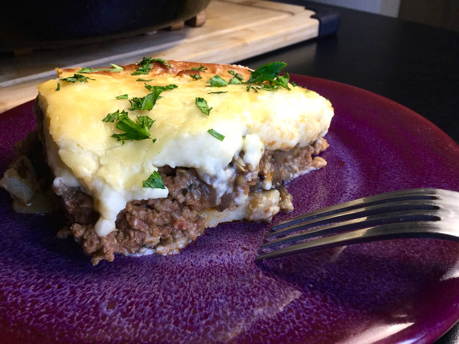 Slice Of Savory Moussaka On A Purple Plate Wallpaper