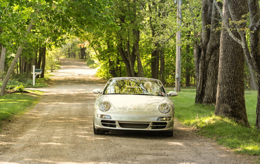 Small Luxury Car On Country Road Wallpaper