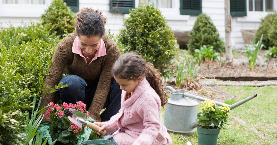 Smiling Mother And Daughter Gardening Wallpaper