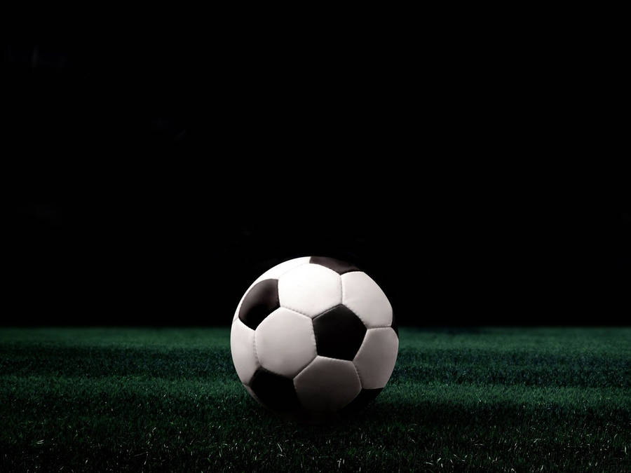 Soccer Ball In Green Field Wallpaper