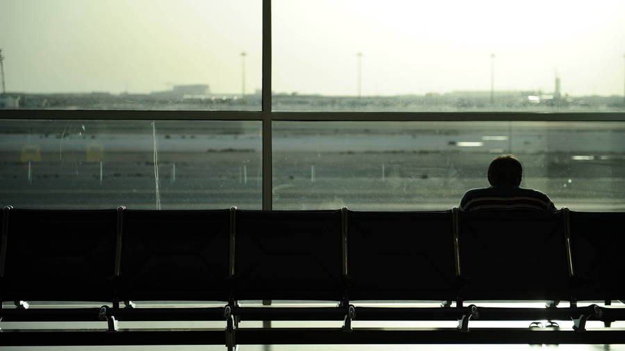 Solitary Man Waiting At Airport Lounge Wallpaper