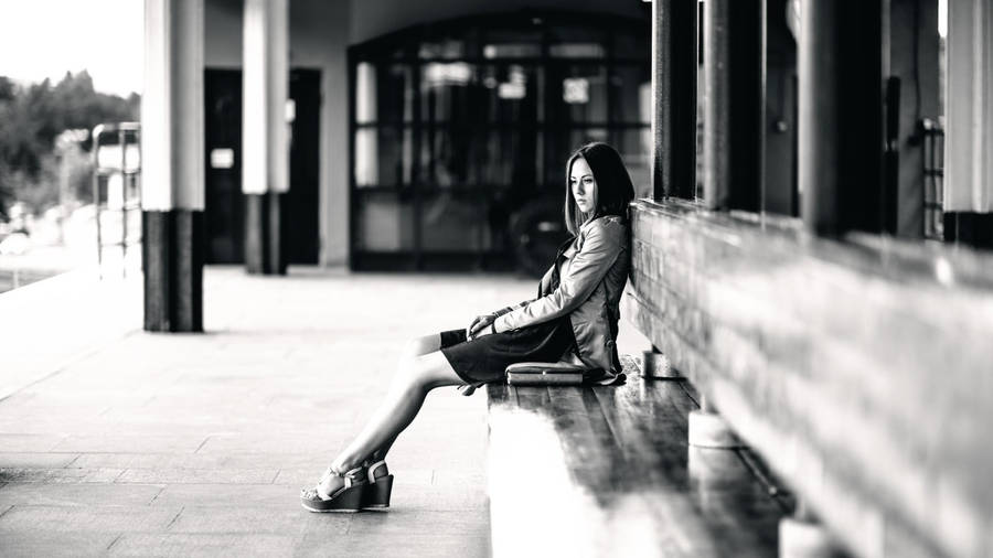 Solitary Moment - A Woman Sitting Alone On A Bench Wallpaper