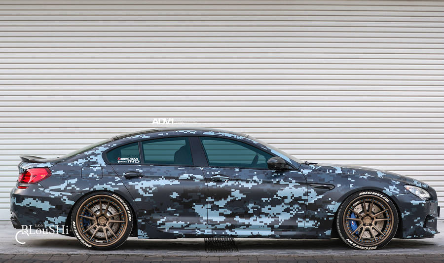 Stealthy Sophistication In The Black Camouflaged Bmw M5 Wallpaper